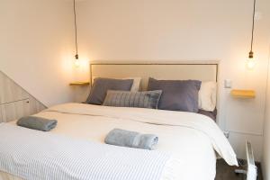 a bedroom with a large bed with two towels on it at Alojamiento Casa Puerto Varas, Cerca del lago in Puerto Varas