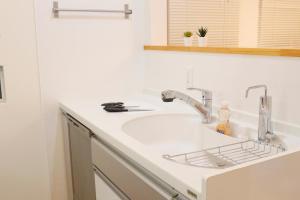 a kitchen counter with a sink and a faucet at Dori Dori House Ebisu in Tokyo