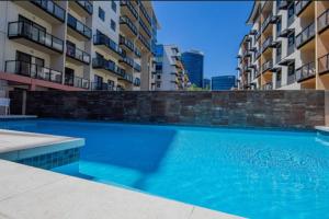 a large swimming pool in front of some buildings at City CBD Retreat in Perth