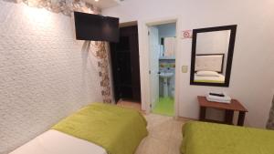 a bedroom with a green bed and a mirror at Paraíso Dorado - Hotel Express in Aguadas