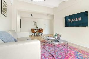 un soggiorno con un divano e un tavolo di vetro di Roami at The Alamac a Miami Beach Altre 19 foto