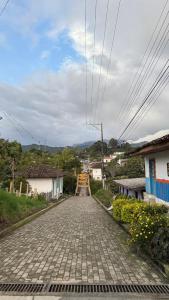 a cobblestone street in a small town with at Un Café en el camino Guest house in Salento