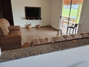 アバレにあるChácara com piscina e lazer em Avaréのソファと薄型テレビのあるリビングルーム