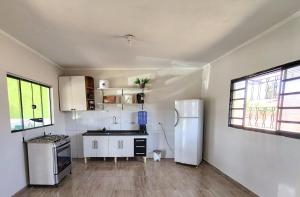 a kitchen with white cabinets and a refrigerator at Chácara com piscina e lazer em Avaré in Avaré