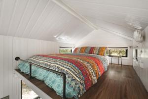 a bed in the middle of a white room at Tiny Hideaway at Cloverhills by Tiny Away in Newham