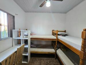 a room with two bunk beds and a ceiling fan at Casa espaçosa até 14 pessoas com estacionamento e a dois quarteirões do metrô Alto do ipiranga in São Paulo