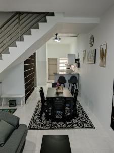 a dining room and kitchen with a table and chairs at ShaFA Homestay in Seri Iskandar +11 photos