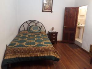 a bedroom with a bed and a wooden floor at Departamento a 1 cuadra de la Plaza Principal in Sucre