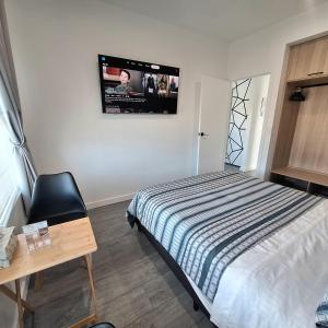 a bedroom with a bed and a tv on the wall at Light Blue in Tullimbar +6 photos
