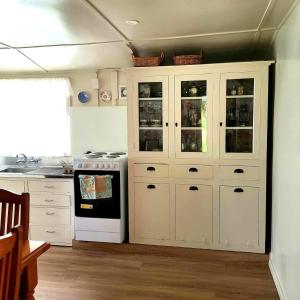 a kitchen with white cabinets and a stove at Little Rose Cottage in Rotherham +27 photos