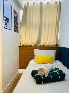 a bed with a yellow pillow and a window at Comfort in the Center 2 Bedrooms Near 25 de Março in Sao Paulo +56 photos