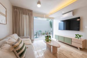 a living room with a couch and a tv at Monne departamento de lujo en Mérida, Planta baja in Mérida