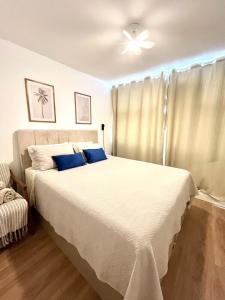 a bedroom with a large white bed with a ceiling fan at Comfort in the Center 2 Bedrooms Near 25 de Março in Sao Paulo