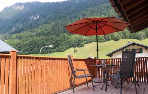 einen Tisch und zwei Stühle mit Sonnenschirm auf einer Terrasse in der Unterkunft Lovely Apartment In Klösterle With Wifi in Klösterle am Arlberg