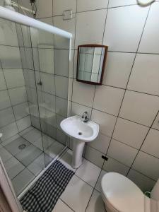 a bathroom with a sink and a shower and a toilet at Hospedaria Allecrim in Santo André