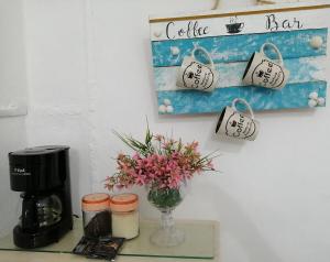 a table with a vase of flowers and a coffee maker at House 50 meters from the beach in Progreso