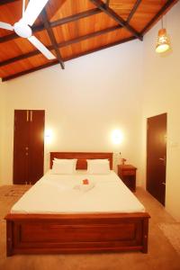 a bedroom with a large bed with white sheets at Hiriketiya Nanda Homestay in Dickwella