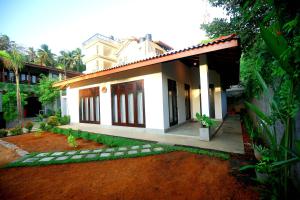 a house with a red dirt yard in front of it at Hiriketiya Nanda Homestay in Dickwella +71 photos