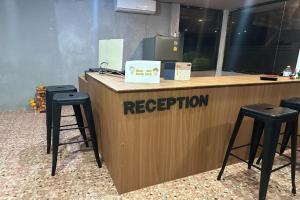 a reception desk with two stools and a counter with a reception at My Pumpkin Bungalow Krabi in Krabi town