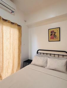 a bedroom with a white bed and a window at WV 29 Homey Hideout in Iloilo City