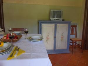 Una mesa con platos y un televisor encima. en Country House Getaway in Apecchio, en Apecchio