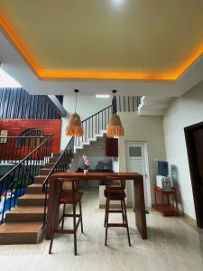 a dining room with a table and a staircase at The Olla Villa in Yogyakarta