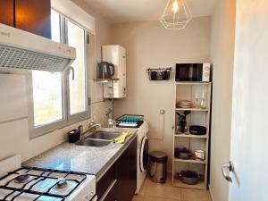 una cocina con fregadero y estufa en Güemes en el centro de Bahía - Amenities, en Bahía Blanca