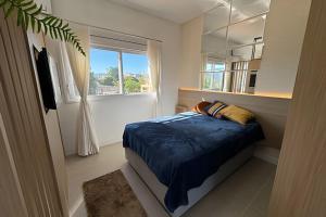 a bedroom with a bed and a large window at Residencial Barin - Perto de TUDO! LZN Hospedagens in Santa Maria