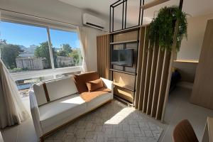 a living room with a couch and a large window at Residencial Barin - Perto de TUDO! LZN Hospedagens in Santa Maria