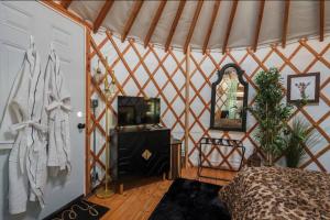 a room with a bed and a mirror in a yurt at Jungle Haven Yurt- Unit #2 in Woodway