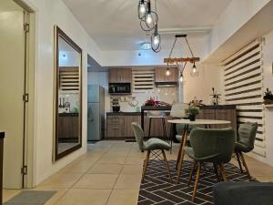 a kitchen and dining room with a table and chairs at RDC Cozy Suite in Tagaytay