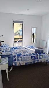 Un dormitorio con una cama y un escritorio y una ventana. en City Stay, en Christchurch