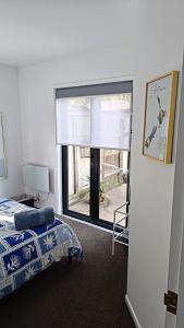 Un dormitorio con una cama y una ventana grande. en City Stay, en Christchurch