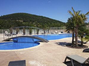 a bridge over a swimming pool with a bridge over a swimming pool at Mobil home confortable avec terrasse pour 6 personnes - API-1-52-393 in Saint-Maurice-dʼIbie