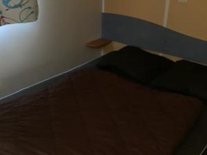 ein Schlafzimmer mit einem Bett mit einem hölzernen Kopfteil in der Unterkunft Mobil-home avec terrasse, 2 chambres, Limeuil - API-1-52-330 in Limeuil + 11 Fotos