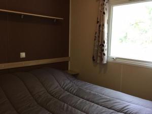 En eller flere senge i et værelse på Mobil-home confortable avec terrasse pour 4 personnes - API-1-52-400 + 27 billeder