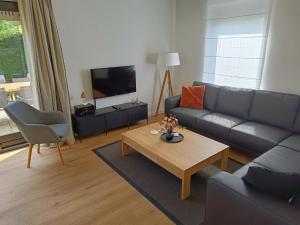 Una sala de estar con un sofá y una mesa de café. en Bungalow in Breskens near the Coast, en Breskens