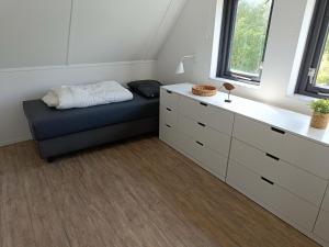 una habitación con una cama, una cómoda y una ventana en Bungalow in Breskens near the Coast, en Breskens 31 fotos más