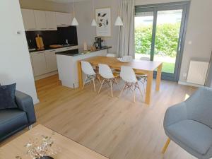 Una cocina y una sala de estar con una mesa y sillas de madera. en Bungalow in Breskens near the Coast, en Breskens