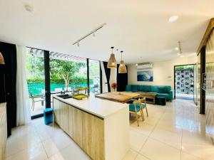 a kitchen and living room with a couch and a table at Oceanami Villa Resort 3 phòng ngủ, 3 phòng tắm - Đầy đủ tiện nghi - Bếp nấu - BBQ - Hồ bơi 2000 m2 - Long Hải Beach in Long Hai