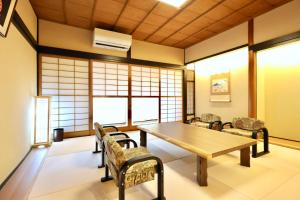 a room with a table and chairs and windows at 善-zen- in Gujo