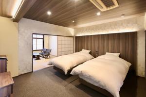 a bedroom with two beds and a television in it at 善-zen- in Gujo