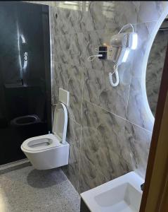 a bathroom with a toilet and a camera on the wall at Lush Homes 