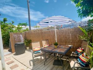 a table and chairs with an umbrella on the beach at Steps to the Sand - Private Beach Access & BBQ Grill in Indialantic