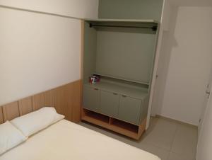 a small bedroom with a bed and a cabinet at Flat08 Tamandaré Carneiros in Tamandaré +8 photos
