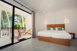 a bedroom with a bed and a balcony at Azul Retreat in Dhigurah