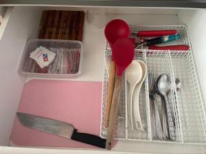 a drawer filled with kitchen utensils and a utensil at Sematan Roxy Beach Apartment in Sematan