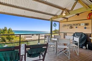 a deck with a table and chairs and a view of the beach at Claytons 7 by Discover Stradbroke in Point Lookout