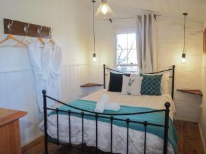 Un dormitorio con una cama con almohadas verdes y blancas. en Gladstone House, en Beechworth