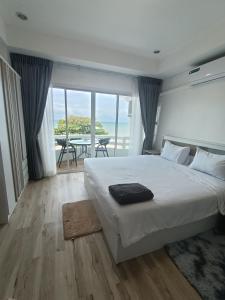 ジョムティエンビーチにあるBeach front D1 Marie Guest houseの海が見える大きなベッドのある寝室 +18枚の写真